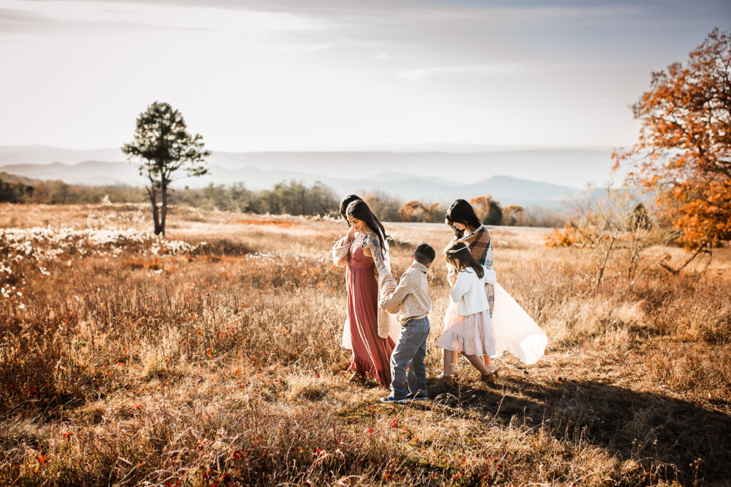 Family walking in field at sunset
