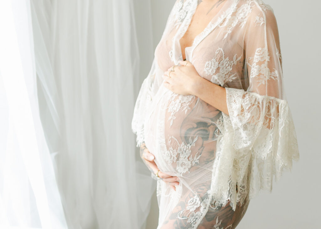 pregnant woman in sheer dress holding belly by dc maternity photographer